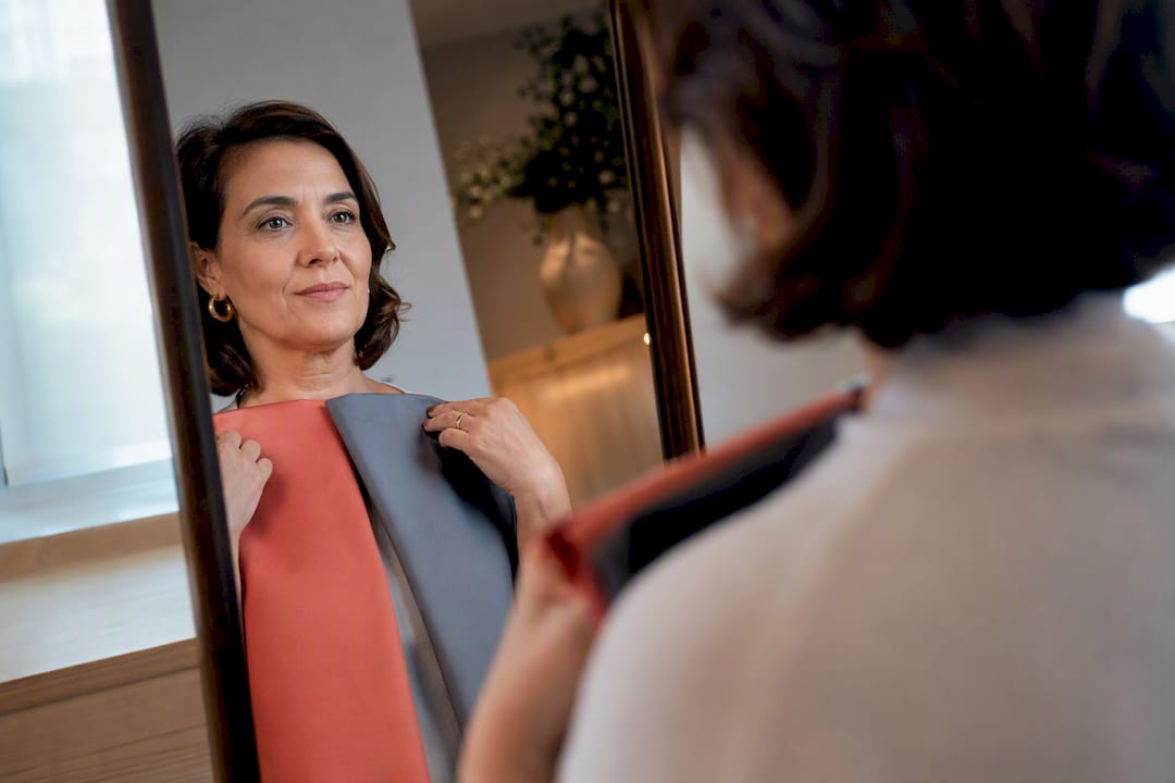 Mulher experimenta tecidos coloridos junto ao rosto